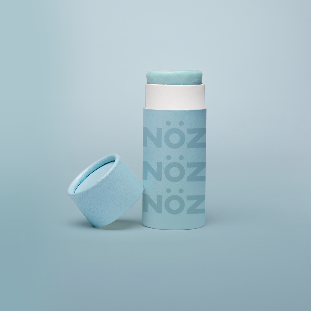 Noz Sunscreen in blue, with the cap off showing the stick of colorful sunscreen inside