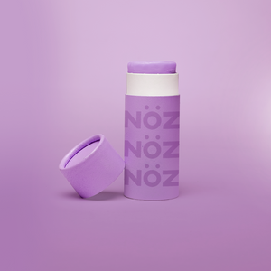 Noz Sunscreen in purple, with the cap off showing the stick of colorful sunscreen inside