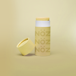 Noz Sunscreen in yellow, with the cap off showing the stick of colorful sunscreen inside.